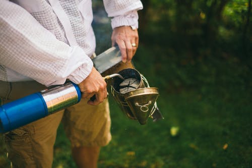 男子手持蓝色丙烷打火机 · 免费素材图片