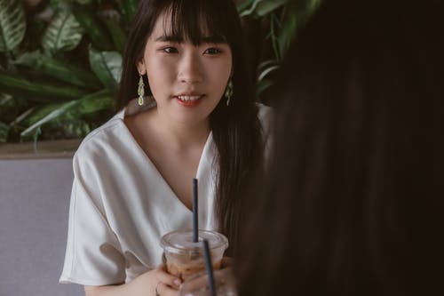 女人拿着塑料杯的照片 · 免费素材图片