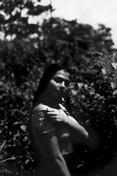 女人站在植物附近的灰度照片 · 免费素材图片