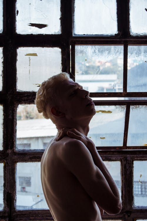 站在窗户附近的人的照片 · 免费素材图片