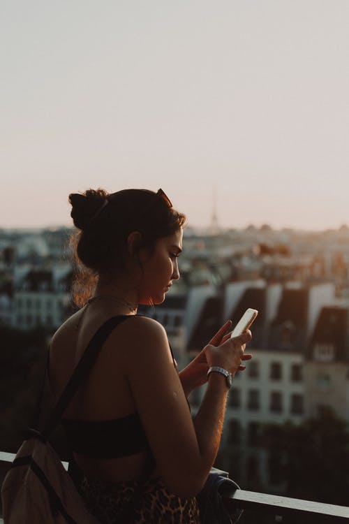 女人抱着她的智能手机的照片 · 免费素材图片