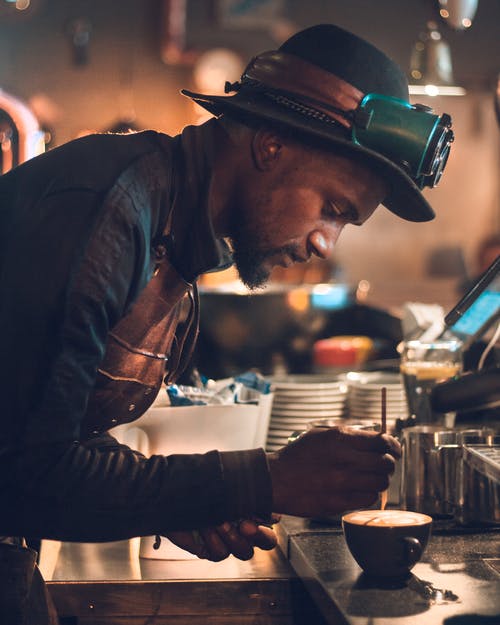 男人在桌子上做卡布奇诺咖啡 · 免费素材图片