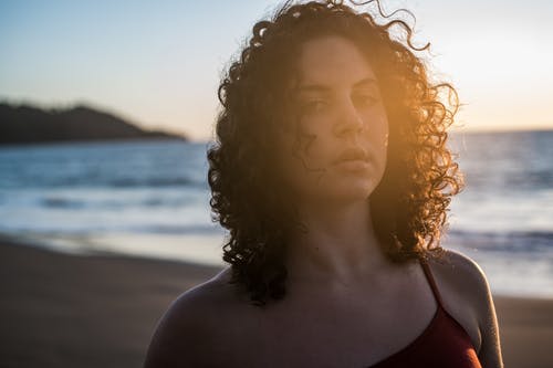 女人站在海滩上的特写肖像照片 · 免费素材图片