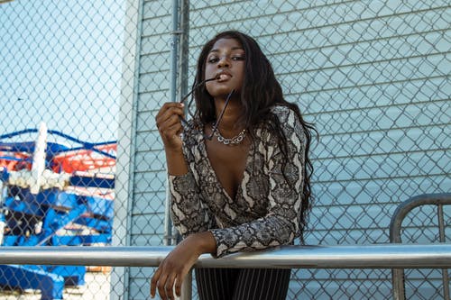 向前倾斜在金属上的女人 · 免费素材图片