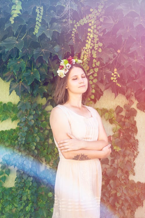 女人站附近墙与藤蔓爬行 · 免费素材图片