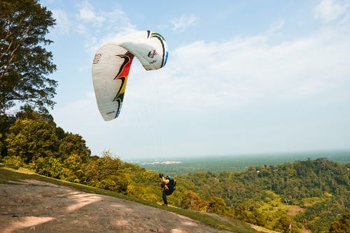 男子手持降落伞 · 免费素材图片