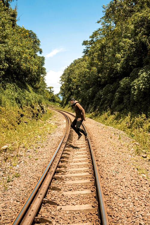 在火车轨道上跳跃的人的照片 · 免费素材图片