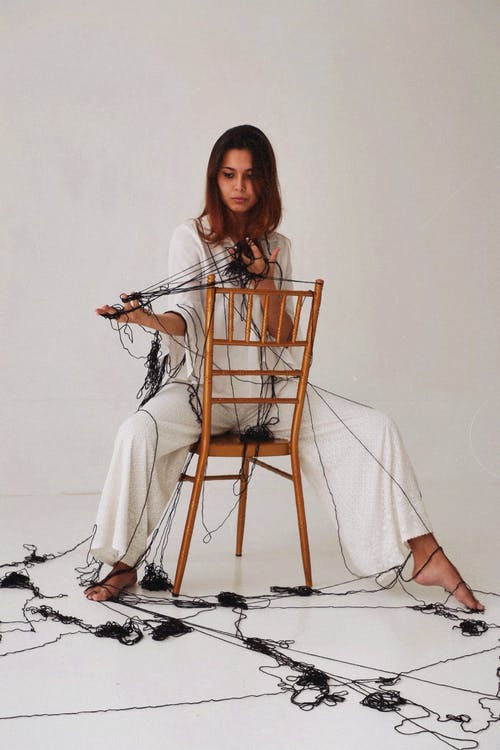 女人坐在棕色椅子上的照片 · 免费素材图片
