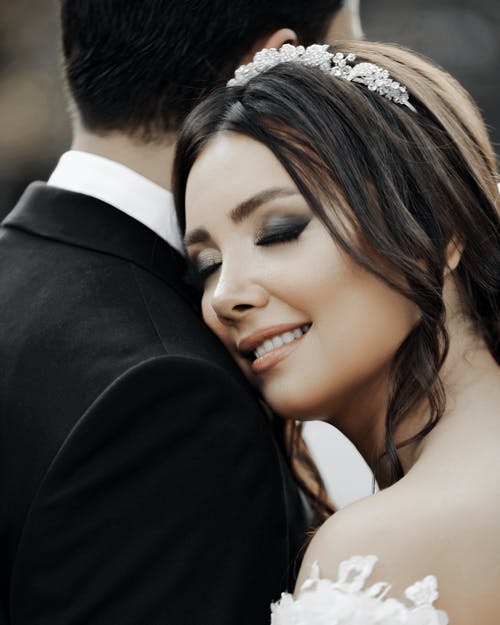 微笑的新娘，她的眼睛的特写镜头关闭拥抱新郎 · 免费素材图片