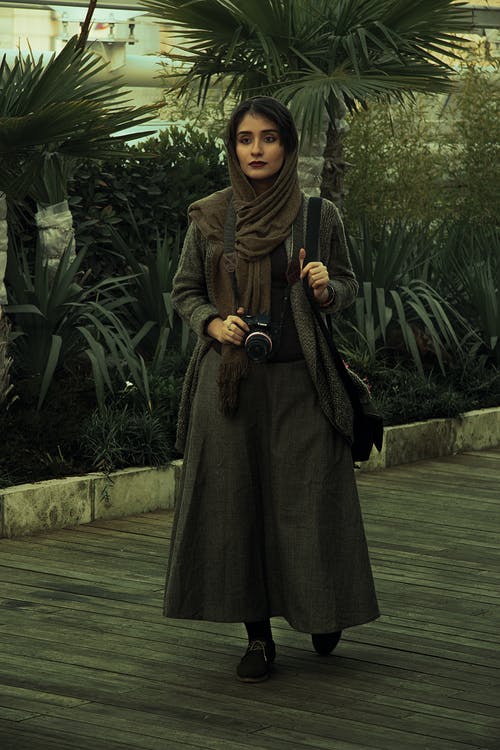 拿着照相机的妇女佩带的围巾 · 免费素材图片