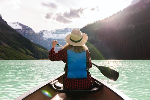 一个女人在湖里划船 · 免费素材图片