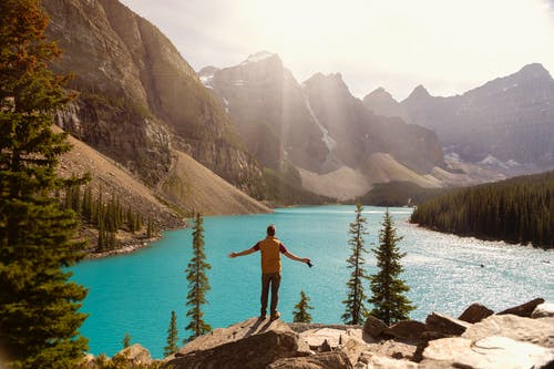 一个男人站在湖上的悬崖上 · 免费素材图片