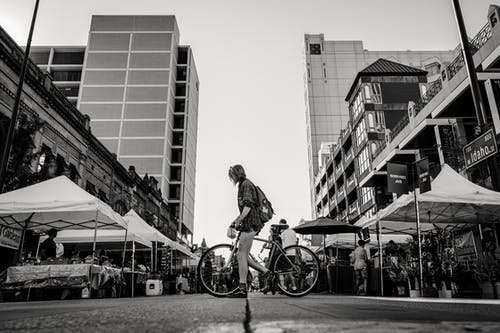 拿着自行车的人的单色照片 · 免费素材图片