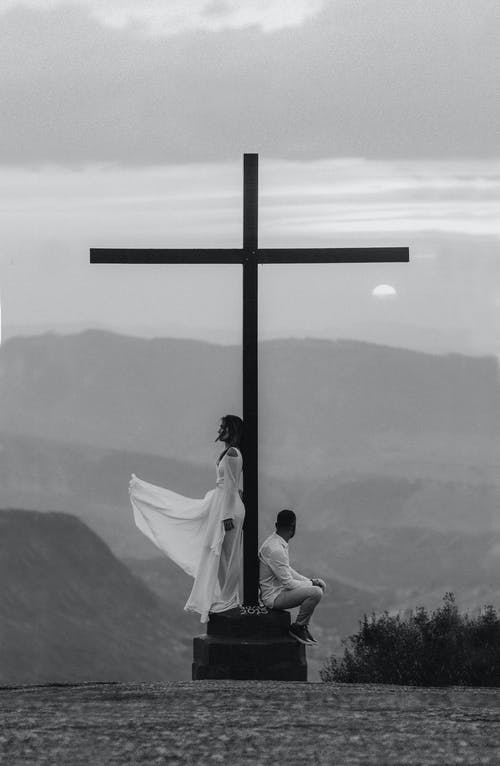 男人和女人在十字架纪念碑上的姿势 · 免费素材图片