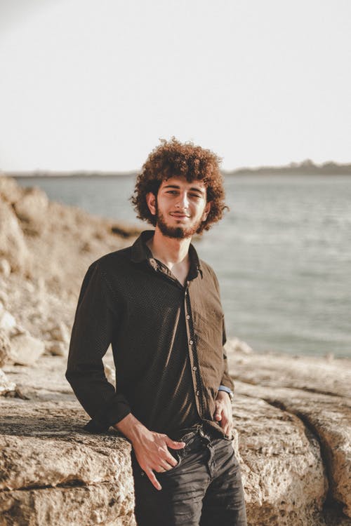 男子斜倚在岩石巨石 · 免费素材图片