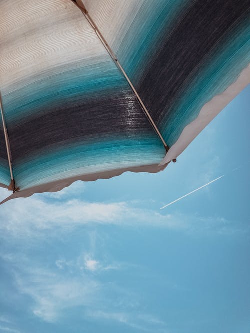 黑色，蓝色和白色的伞，在蓝蓝的天空下 · 免费素材图片
