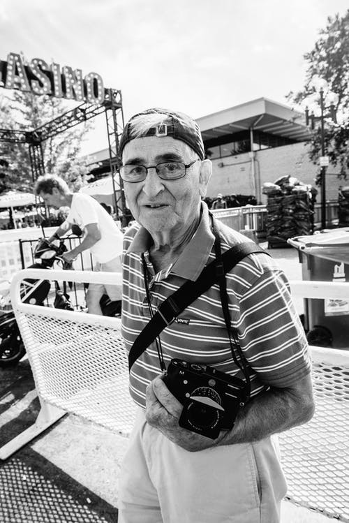 男子手持相机的灰度照片 · 免费素材图片