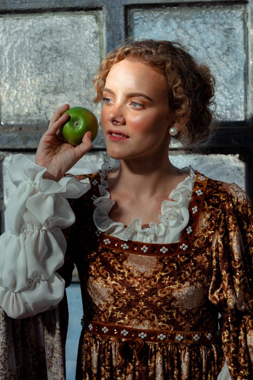 历史服装的梦幻般的女人与窗口附近的苹果 · 免费素材图片