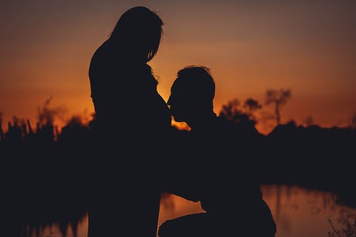 男人亲吻他的妻子怀孕的肚子的剪影照片 · 免费素材图片