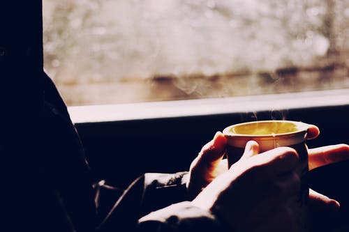 拿着棕色杯子的人 · 免费素材图片