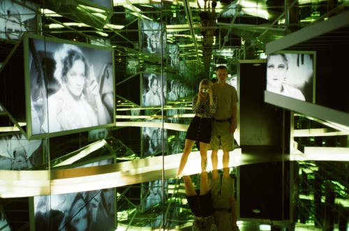 男人和女人站在玻璃室内的女人的近照片 · 免费素材图片