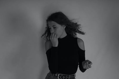 女人站在墙前的灰度照片 · 免费素材图片