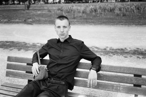 男人坐在板凳上的单色照片 · 免费素材图片