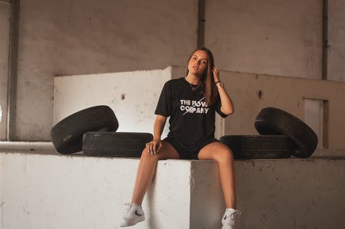 坐在轮胎附近的女人的照片 · 免费素材图片