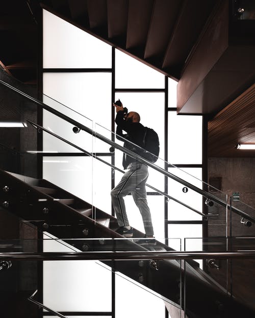 男子站在楼梯上拿着相机 · 免费素材图片