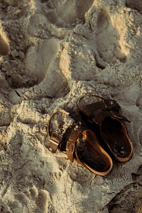 沙滩上的棕色凉鞋 · 免费素材图片