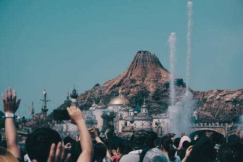 人群与白烟大厦前 · 免费素材图片