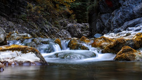 在岩石附近的水体的低角度照片 · 免费素材图片