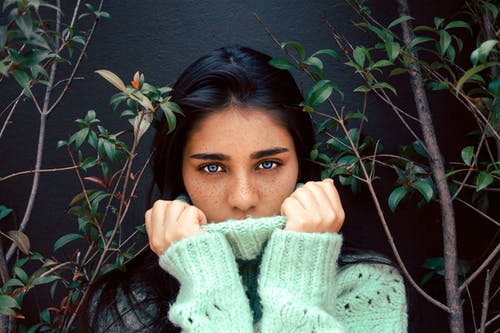 女人穿着绿色的植物以外的针织的毛衣 · 免费素材图片