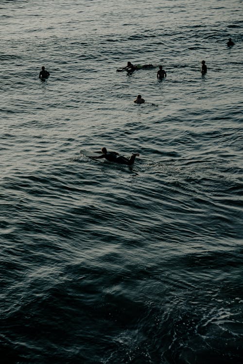 人们骑在冲浪板上附近的人看着 · 免费素材图片