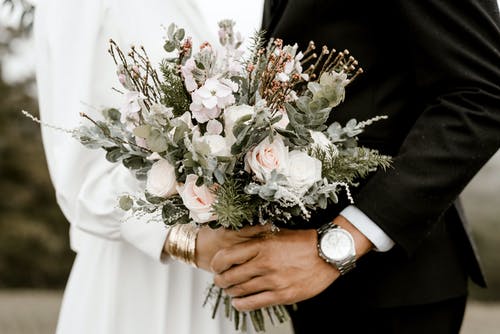 新郎和新娘站着鲜花花束 · 免费素材图片