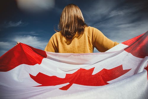 女人抱着加拿大国旗 · 免费素材图片