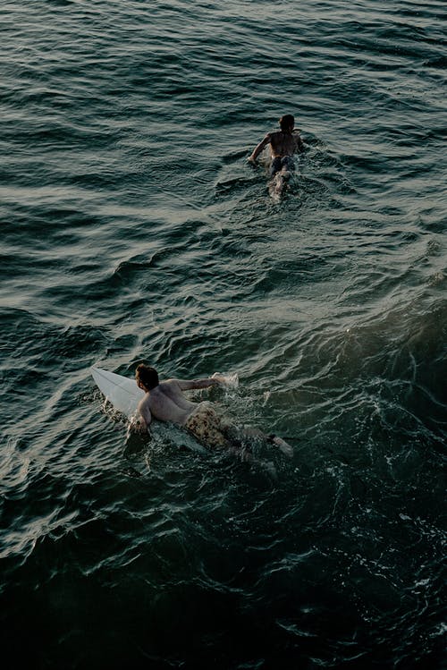 在海洋中冲浪的人的照片 · 免费素材图片