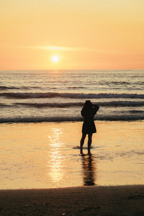 女人站在海边的剪影照片 · 免费素材图片