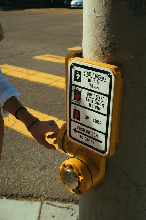 警告标志附近的人的手照片 · 免费素材图片