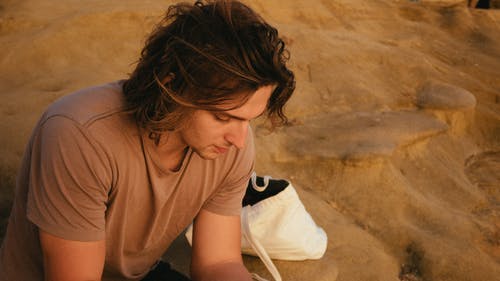 男子坐在岩石上的照片 · 免费素材图片