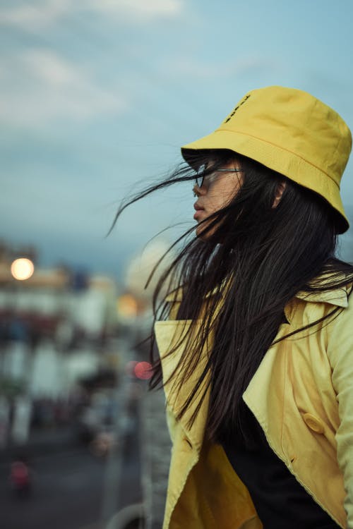 女人穿着黄色外套和黄色桶帽子 · 免费素材图片