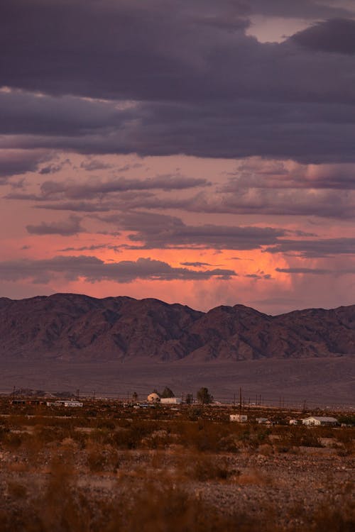 灰色和橙色的天空下的棕色领域 · 免费素材图片