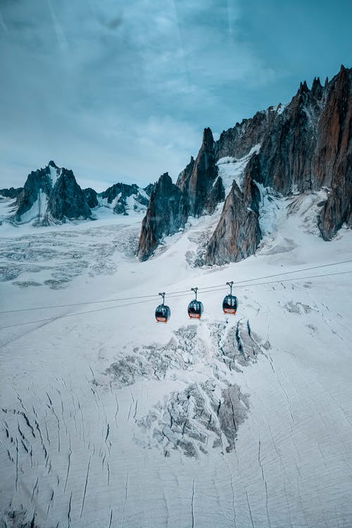 三辆缆车在白雪覆盖的山脉 · 免费素材图片