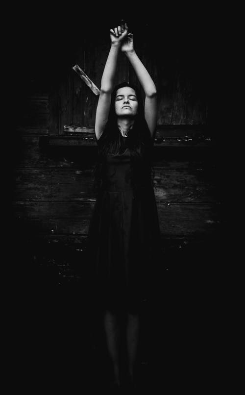 女人站着她的手，闭上眼睛的灰度照片 · 免费素材图片
