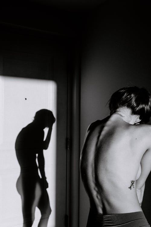 裸照的女人站在阴影附近 · 免费素材图片