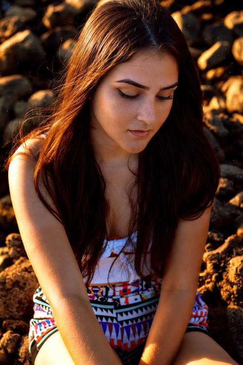 女人坐在地面上的特写照片 · 免费素材图片