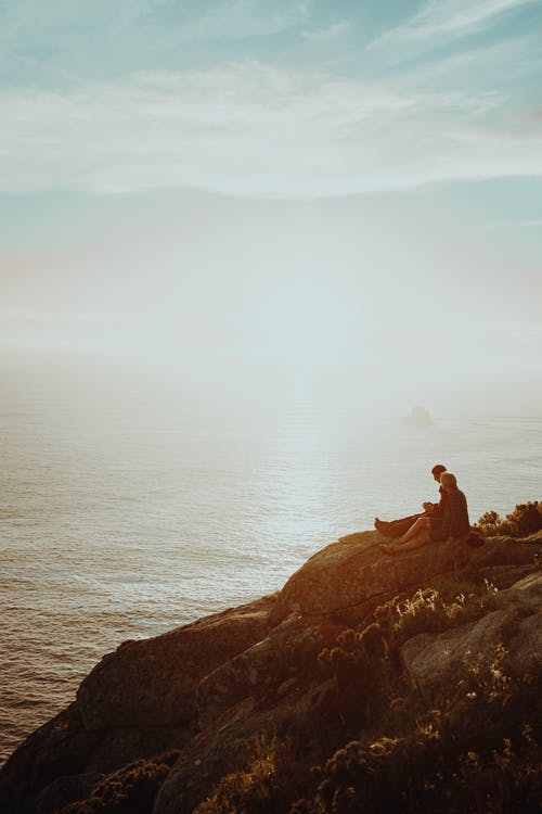 两人坐在悬崖上 · 免费素材图片
