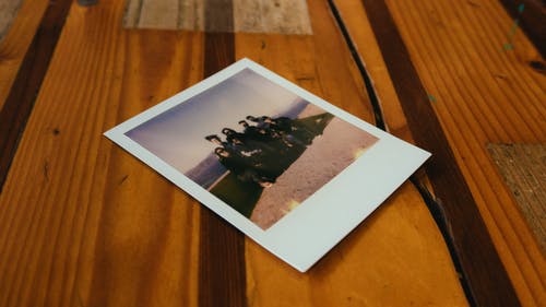 棕色的木桌上的即时照片 · 免费素材图片