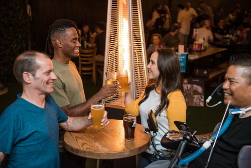 桌子旁边的四个微笑的人与饮料 · 免费素材图片