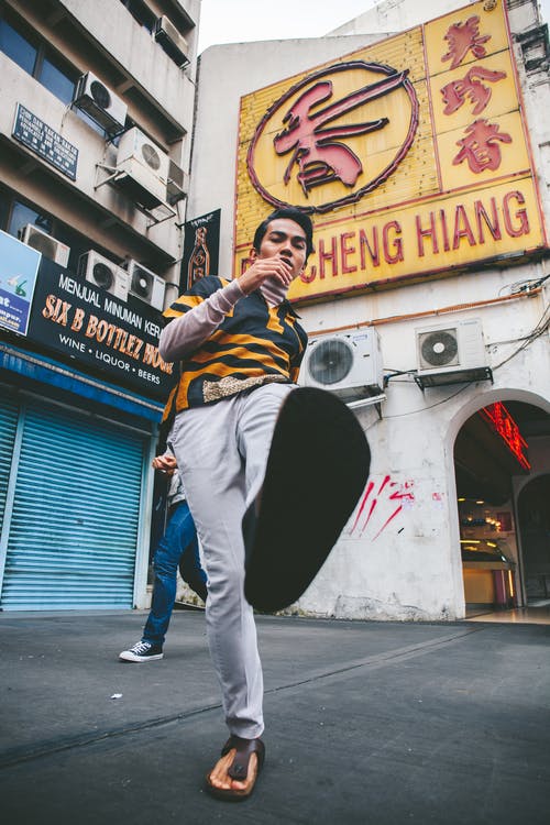 黄色和黑色衬衫和白色裤子的男人 · 免费素材图片